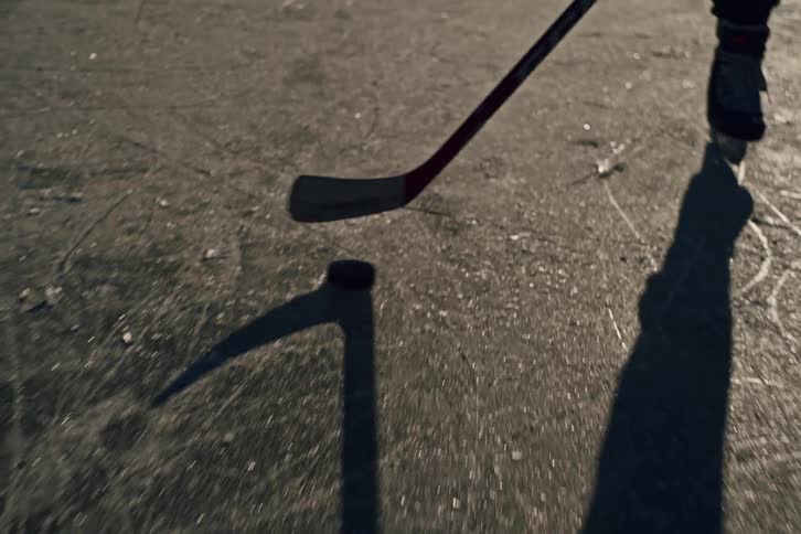 Dekeing the puck across the ice on an outdoor frozen pond