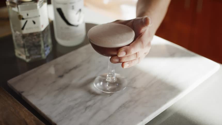 A person lifts the mixed drink