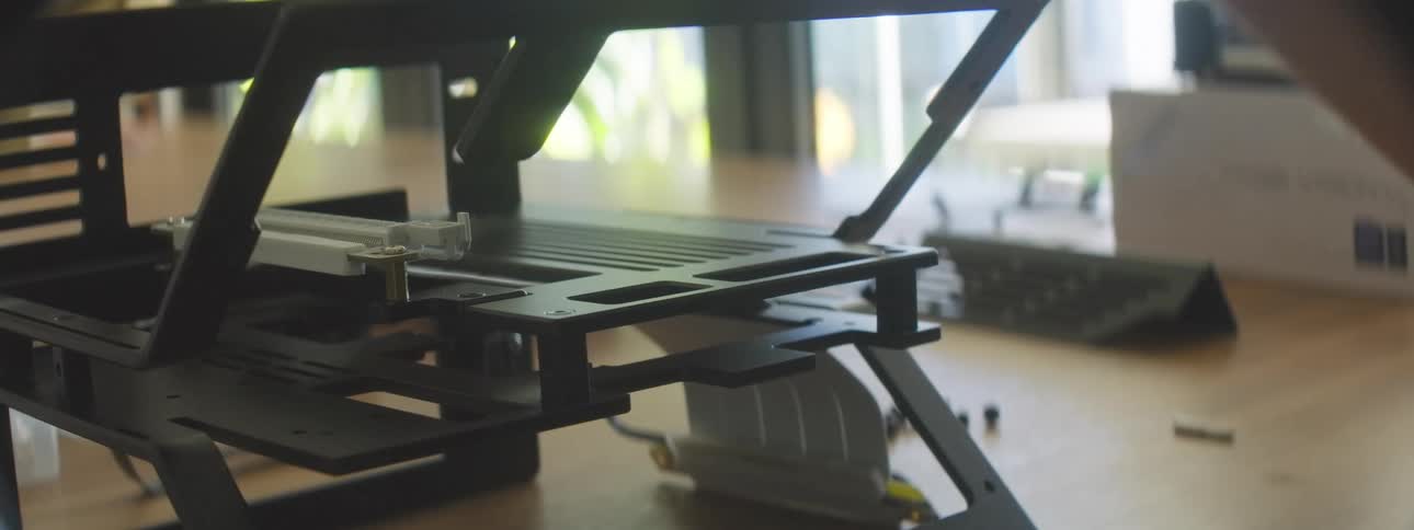 A closeup shot shows a hand adjusting a small screw on a computer metal frame