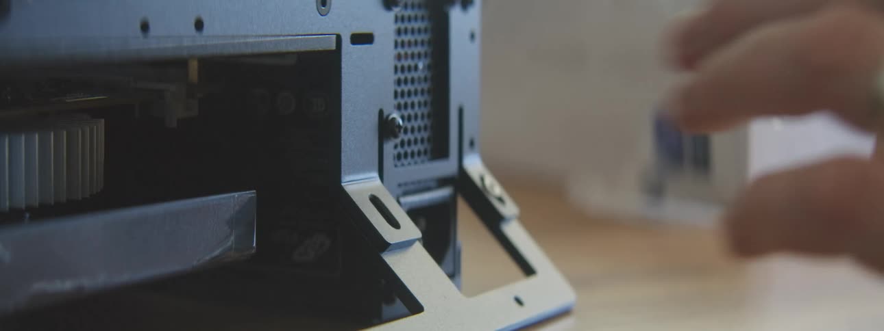Hand with a screwdriver screwing parts of a computer