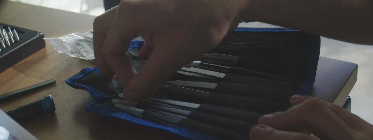 A person removes a tweezers from a bag