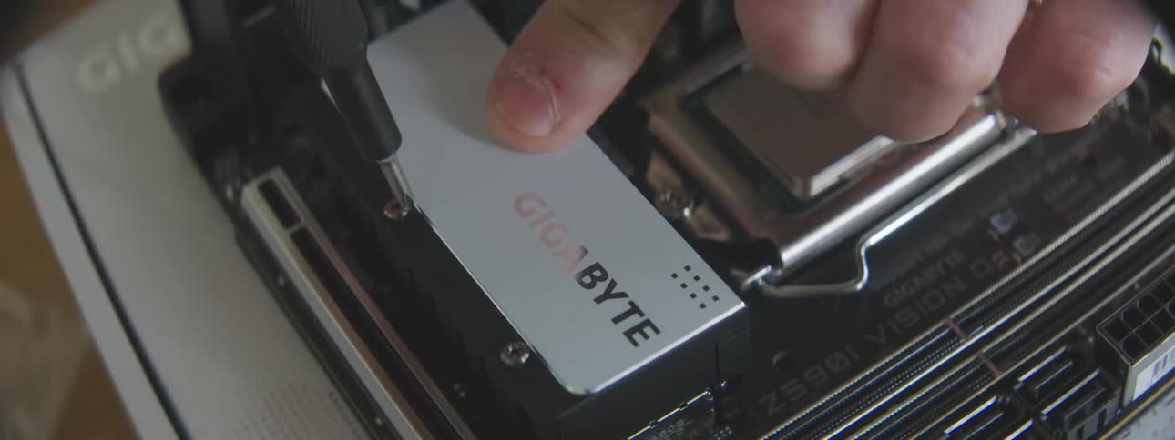 Hand installing a gigabyte ssd into a computer motherboard