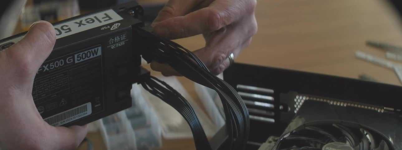 Pair of hands configuring cables on a computer power supply