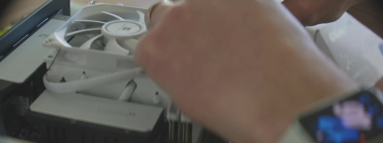 Pair of hands putting cables into a computer setup