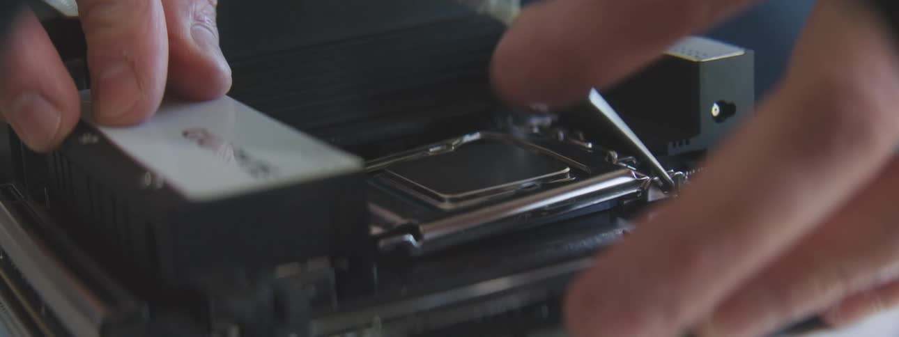 Two hands carefully installing a processor in a computer motherboard