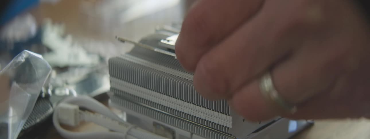 Hand screwing the clip of a processor heatsink