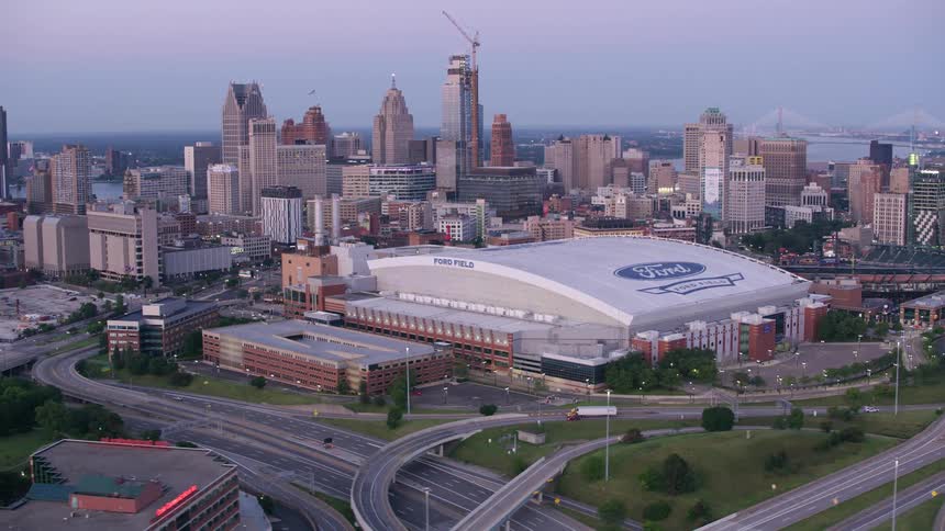 Aerial view of a covered stadium in the middle of a metropolis