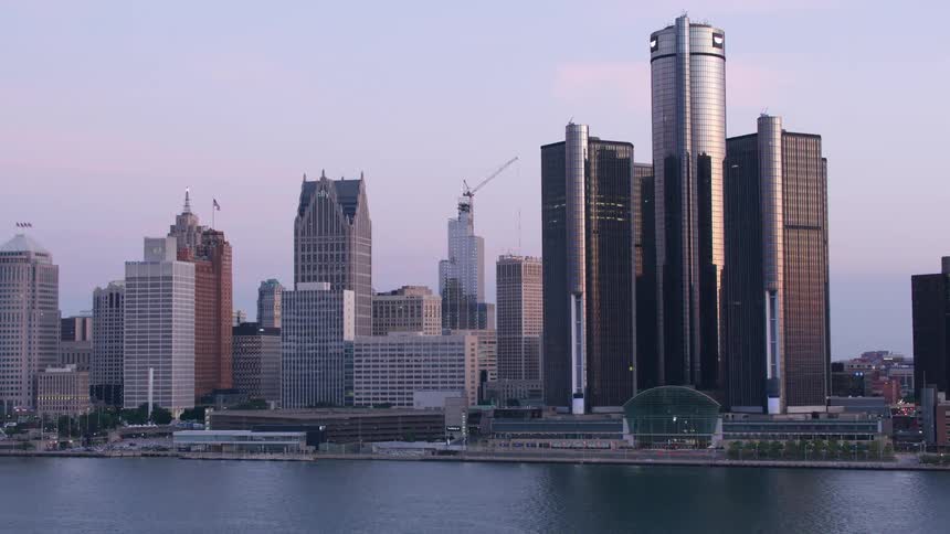 Panoramic view of an urban skyline reflecting the soft evening light on the edge of a river