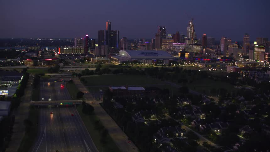 Aerial view of a city illuminated at dusk with busy avenues and skyscrapers in the background