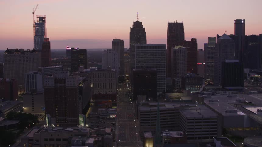 Aerial view of a city at dusk with skyscrapers and illuminated streets