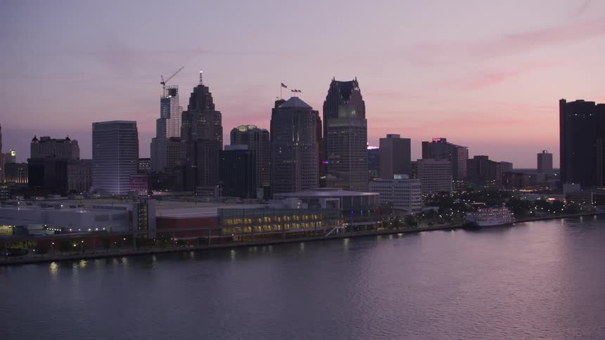 An aerial view of the detroit skyline at dusk highlighting various skyscrapers against the twilight sky