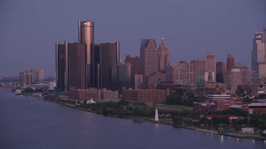 An aerial view shows the detroit skyline at dusk featuring the renaissance center along the detroit river