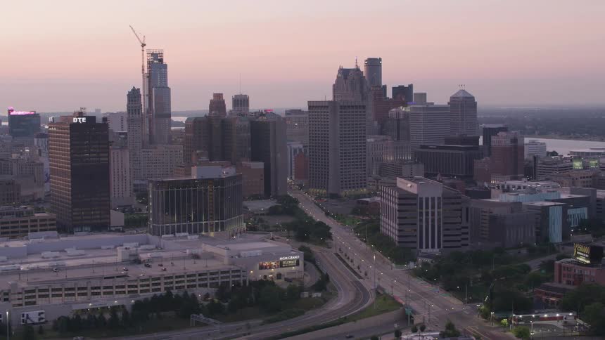 Aerial view of a city at dawn with skyscrapers illuminated by the soft sunlight