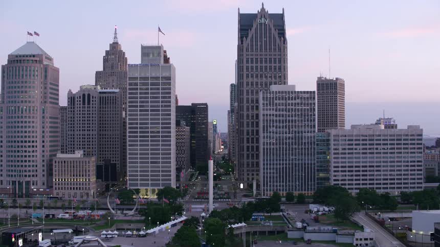 An aerial view captures the detroit skyline at dusk showcasing various skyscrapers against a muted dusk sky