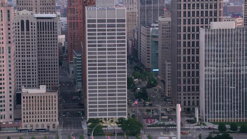Skyscrapers surround a busy square in the city center at dusk
