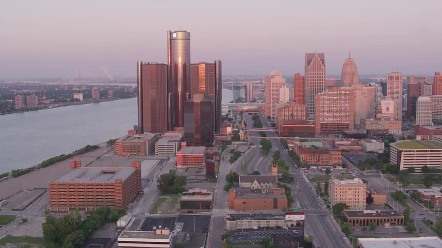 An aerial shot shows the detroit skyline at dusk featuring the renaissance center along the detroit river