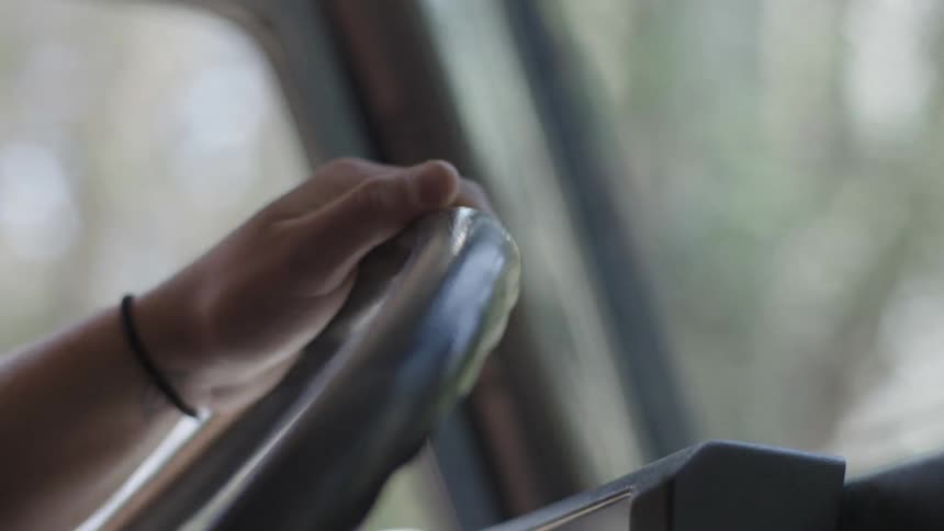 A person steers while driving a vehicle