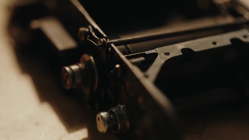 An old mechanical device reveals intricate gears and worn metal parts hinting at its past use and craftsmanship