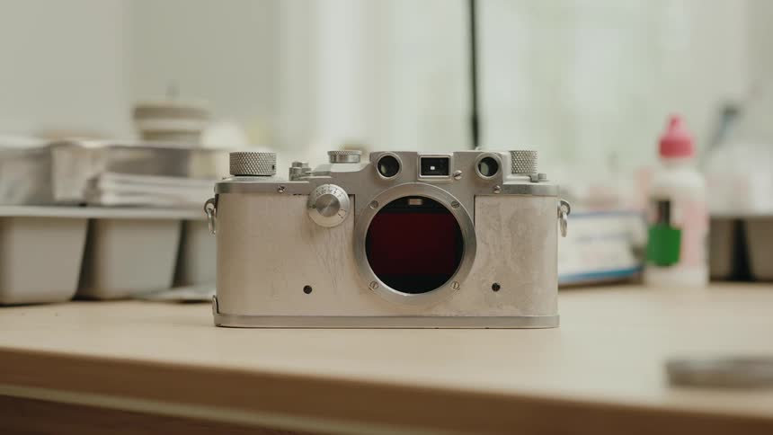Camera stands on a flat surface near bottles and cotton swabs