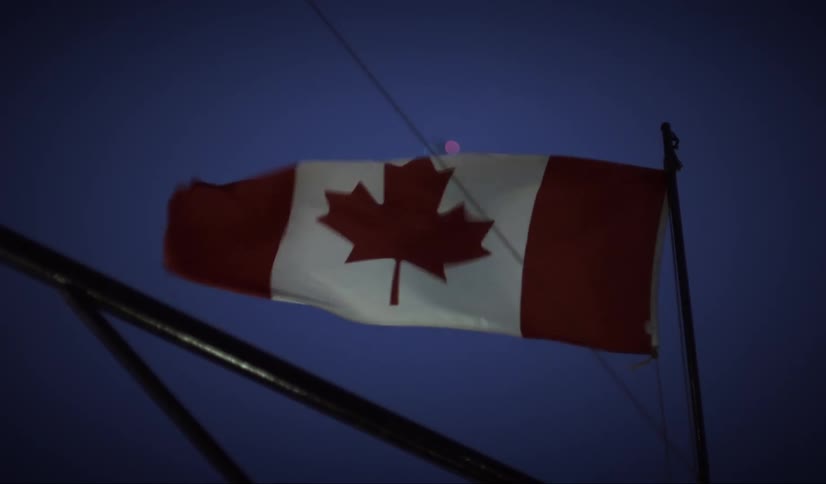 Canadian flag blowing in the wind outdoors at night
