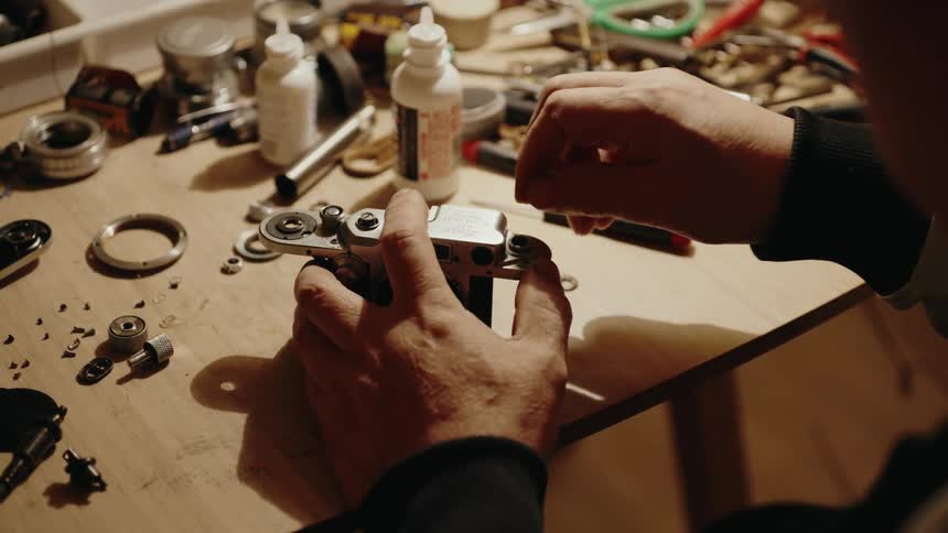 Pair of hands working on a vintage camera