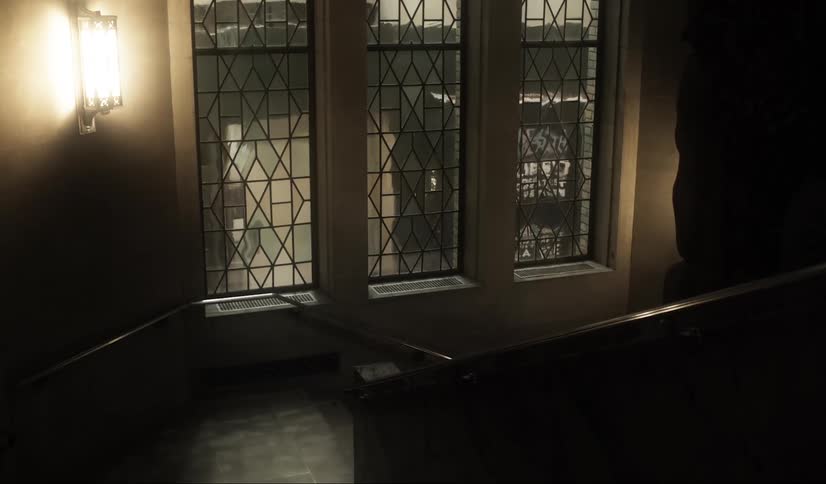 Interior view of a hallway with stairs and lights on