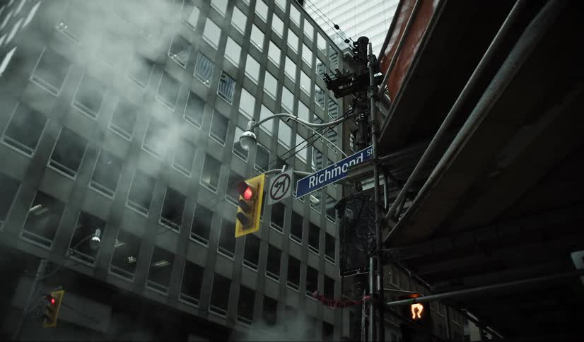 Traffic light with the red light on in the middle of buildings in a metropolis