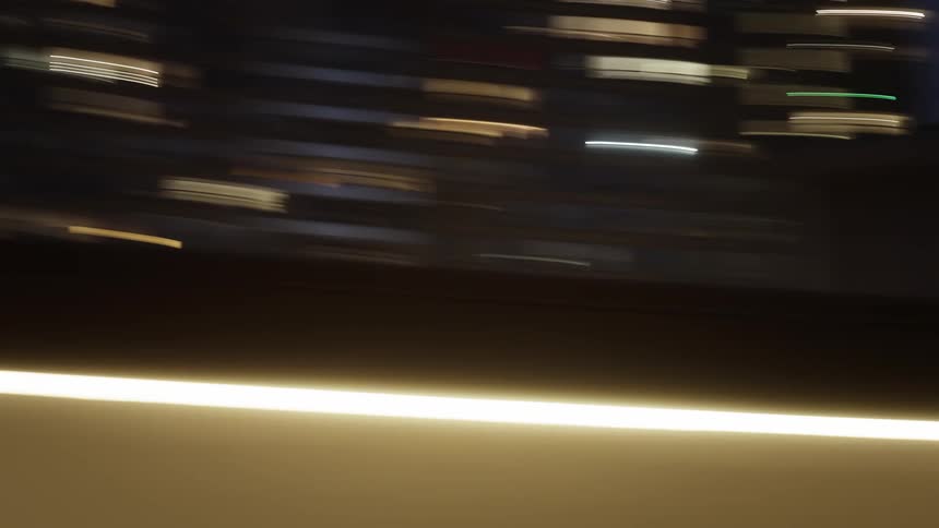 Blurred view of tall buildings in a metropolis lit up at night