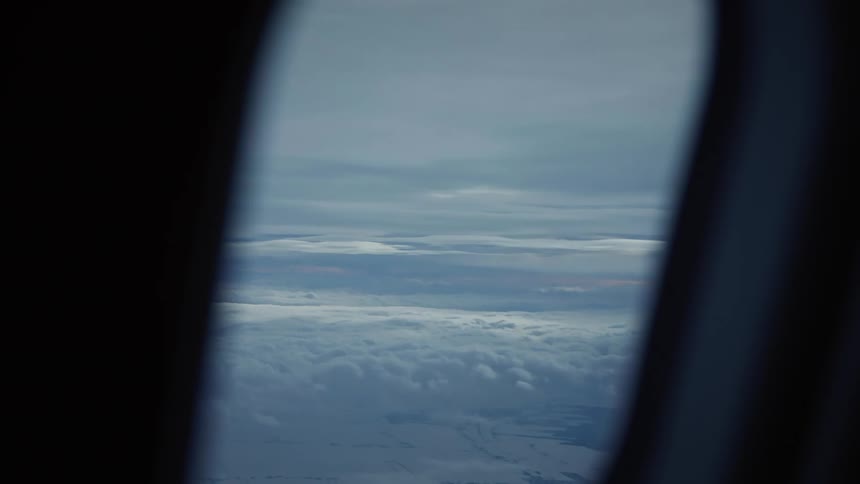 Landscape of sky with clouds seen through the window of an airplane