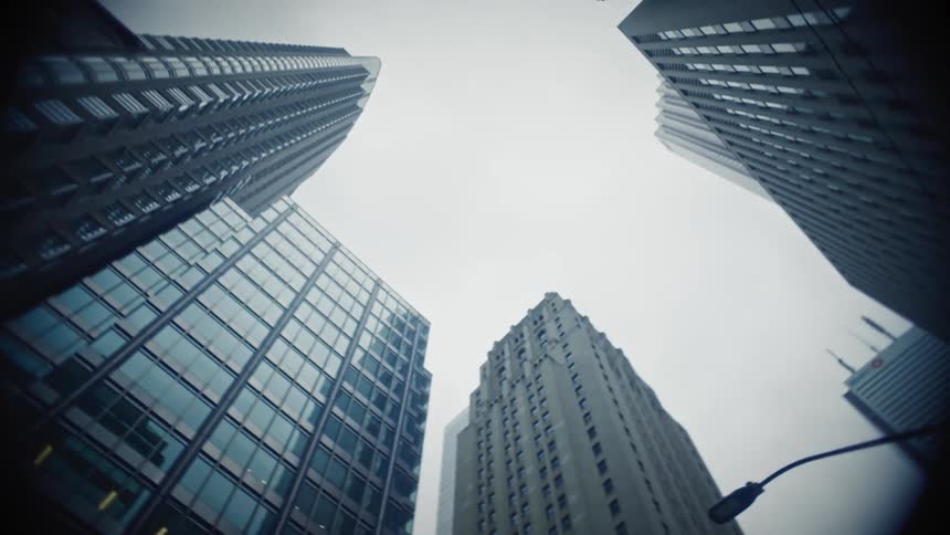 Upward view of modern skyscrapers against a cloudy sky