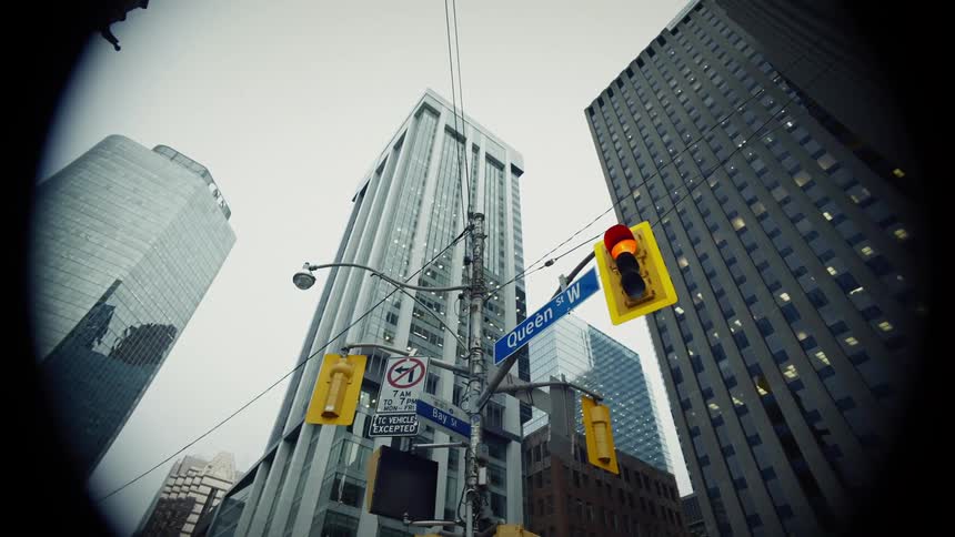 Traffic light signals change at an intersection downtown near some sky scrapers