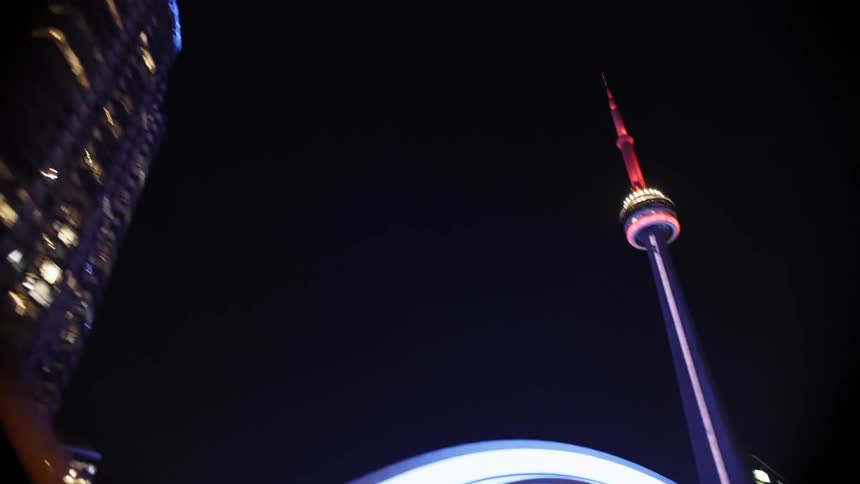 Cn tower next to illuminated skyscrapers at night