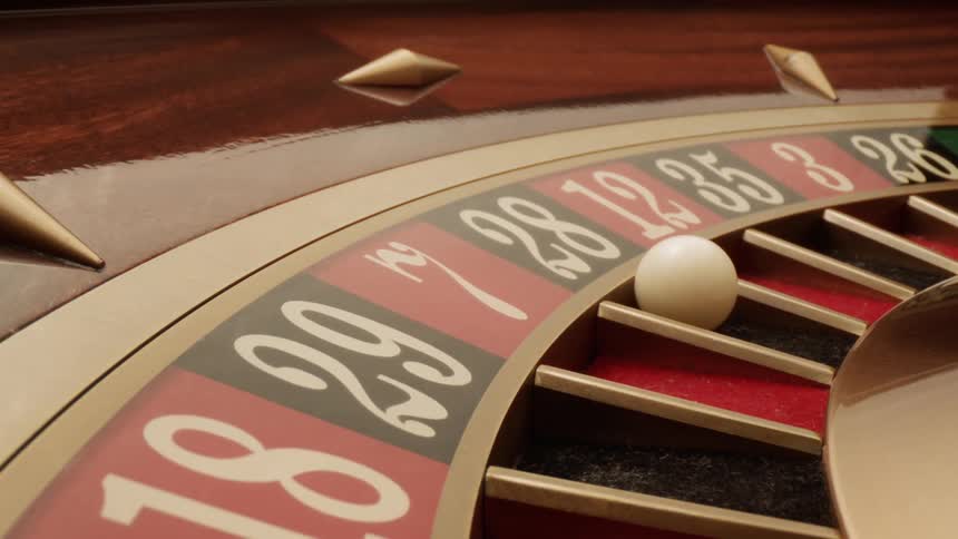 A close up of a roulette wheel with a white ball falling into a numbered slot