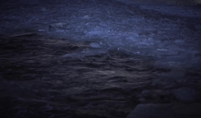 Water from a lake flowing through the ice