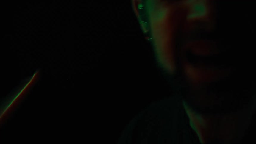 Portrait of a bearded man in a dark environment singing vibrantly