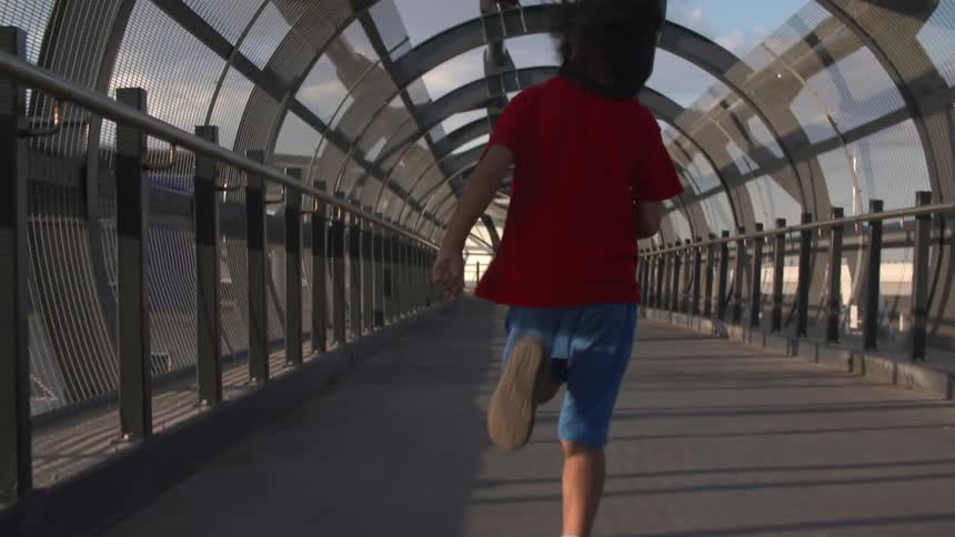 A kid running outside on a sunny day