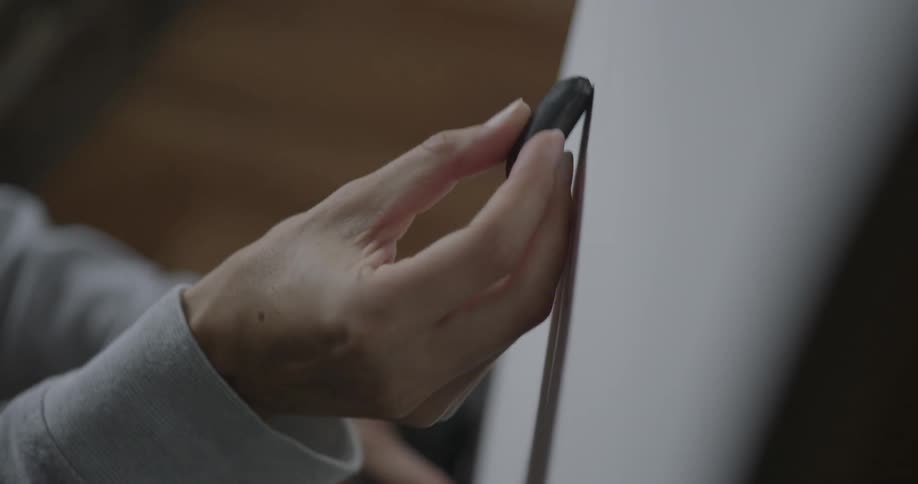 A woman sketches on a piece of paper