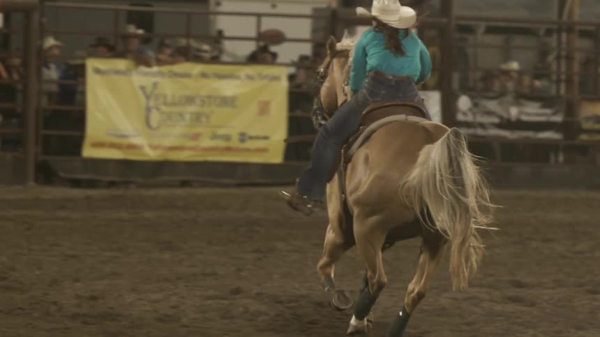 Cowgirl riding a horse at a rodeo