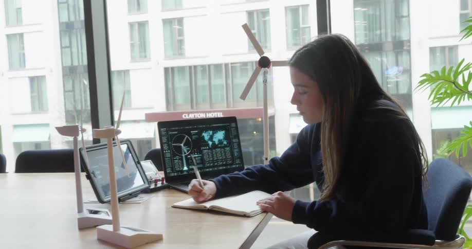 A girl is writing in her notebook at the desk