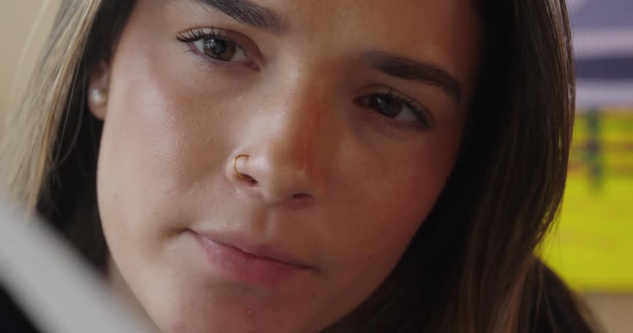 Closeup of a longhaired womans face looking at something with a concentrated expression