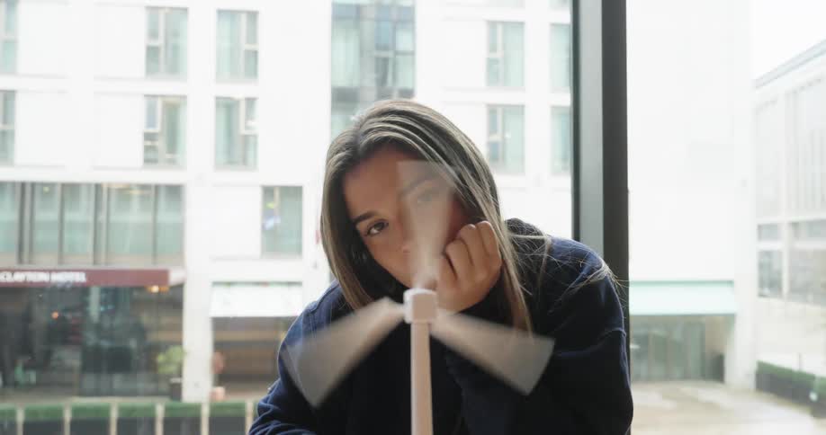 Woman removing the suction cup from a miniature prototype of a wind power engine