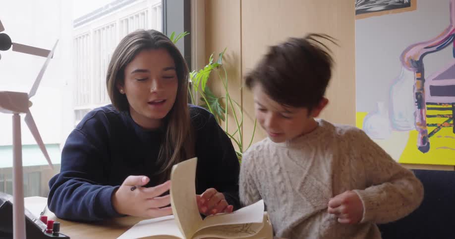 Young woman next to a boy reading to him