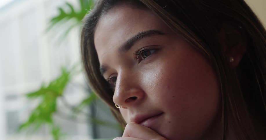 Young woman rests her face on her hand