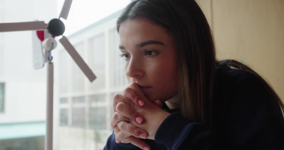 Woman typing on a laptop and getting thoughtful
