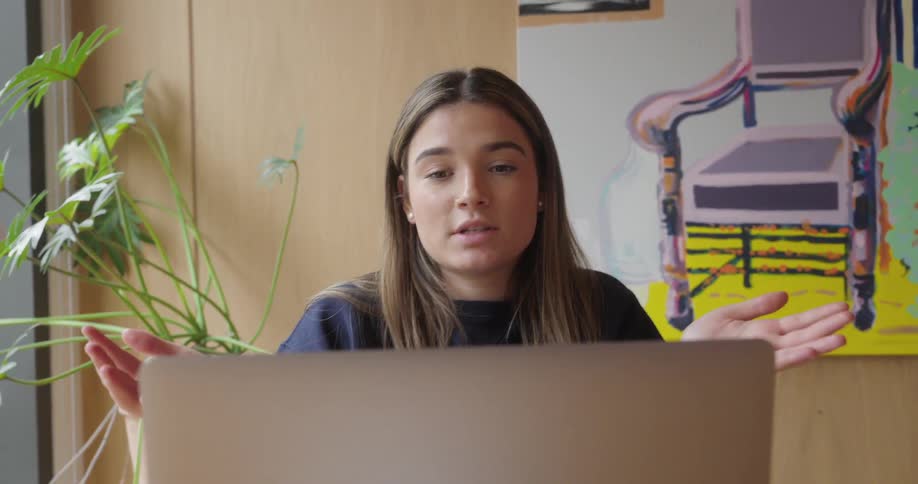 Portrait of a woman in a meeting interacting with a laptop