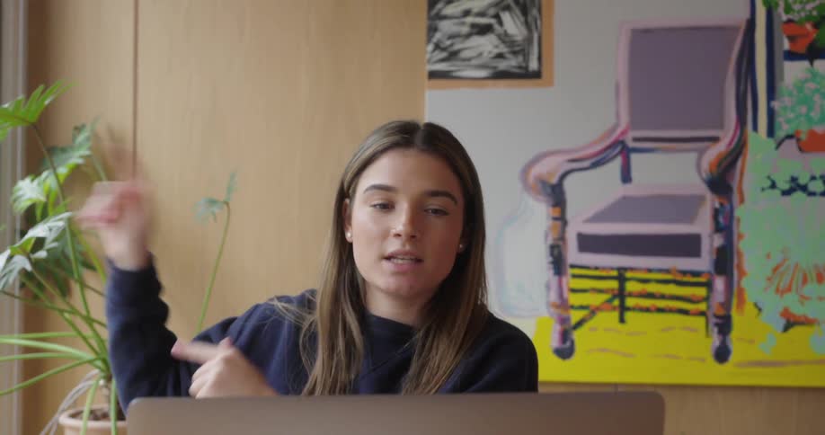 Woman gestures animatedly while interacting during a video conference