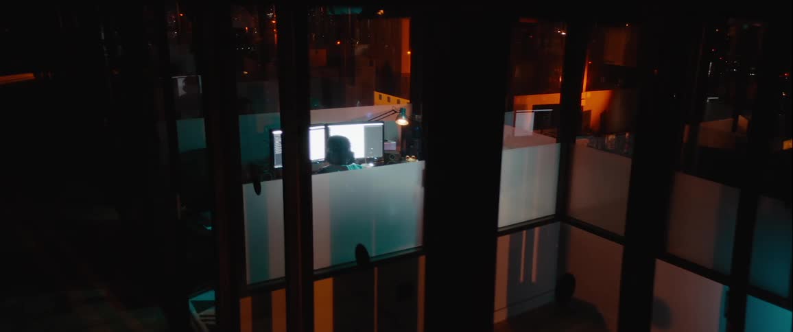 Person inside an office room at night with computer on