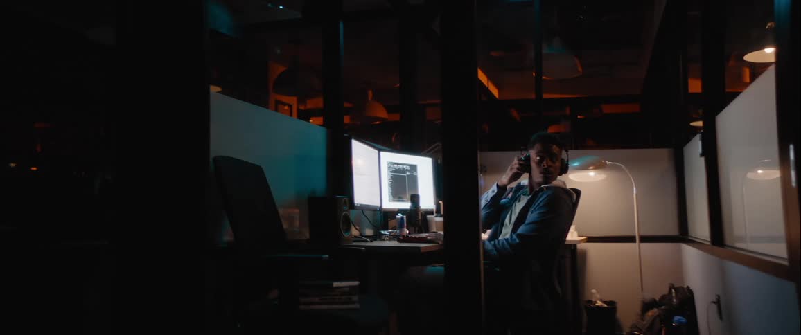 Man sitting at an office desk at night working on a computer