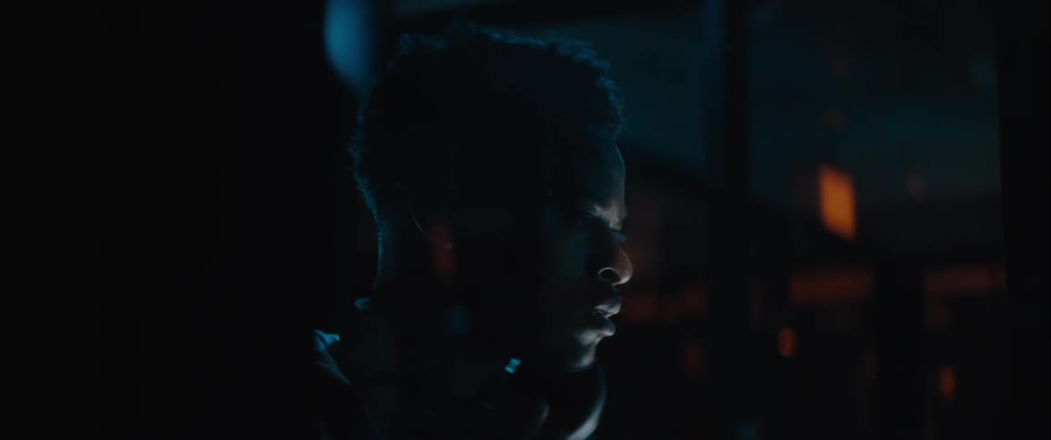 A man looks around nervously in the dark