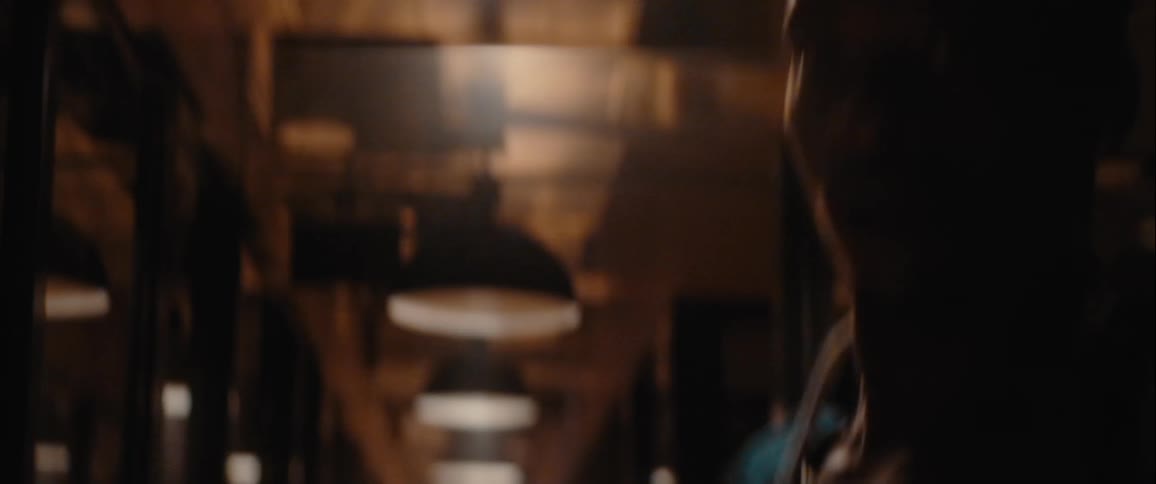 A man runs away as all the lights turn on in the dark hall